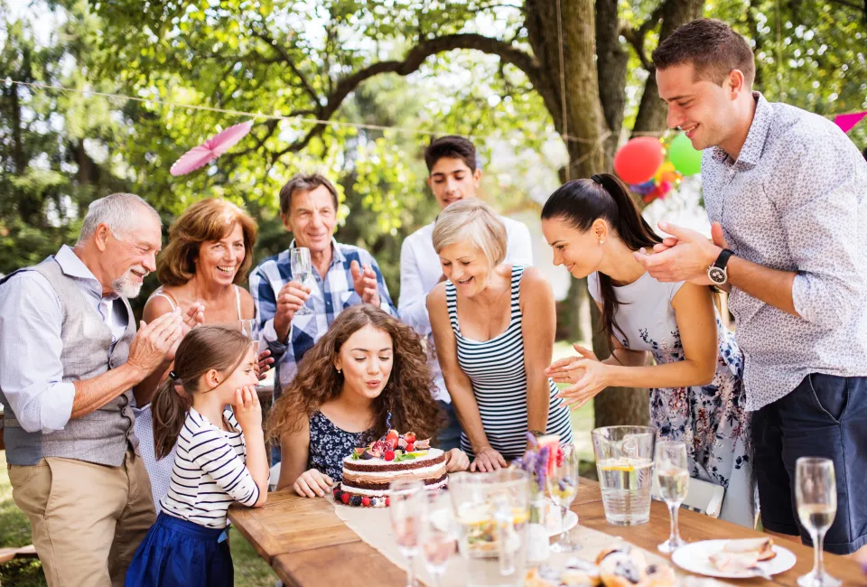 Familie feiert Geburtstag an einer Tafel im Grünen